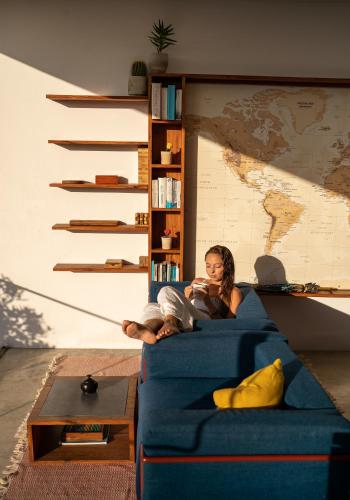 a woman sitting on a blue couch at Duna Sonambula in Praia do Tofo