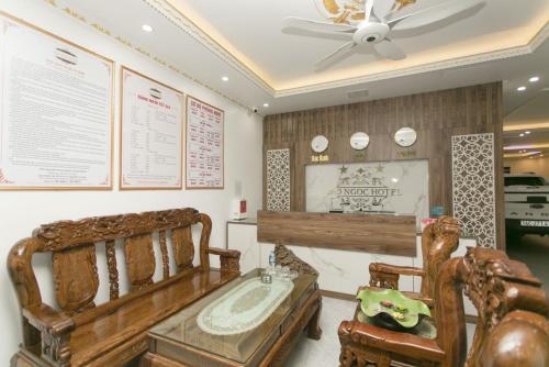 a room with a bed and two chairs and a ceiling fan at Bảo Ngọc Hotel in Uông Bí