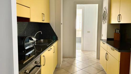 a kitchen with yellow cabinets and a sink at N276 - Numana, bilocale fronte Spiaggiola con piscina in Numana
