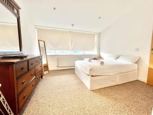 a bedroom with a bed and a dresser and a mirror at Duplex on the Docks - Free WiFi/Parking in Liverpool