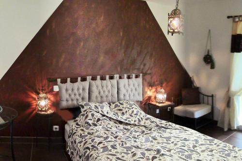 ein Schlafzimmer mit einem großen Bett mit einem großen Kopfteil in der Unterkunft Villa de 2 chambres avec piscine privee terrasse et wifi a Lalbenque in Lalbenque
