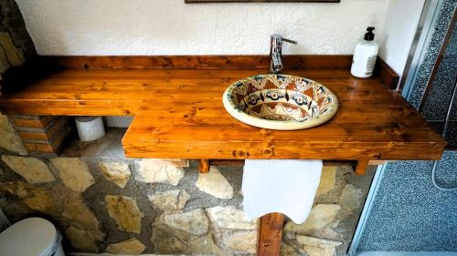 卡索拉爾的住宿－CAZORLA, CASA RURAL LA GUINDALERA，木桌上带水槽的浴室
