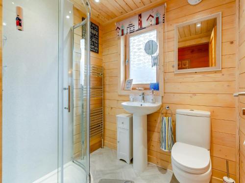 y baño con aseo, lavabo y ducha. en Seashell Lodge, en Gairloch