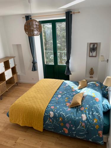 une chambre avec un lit avec une couette bleue et une fenêtre dans l'établissement Maison centre-ville avec extérieurs, à Lannion