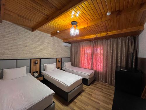een slaapkamer met 2 bedden en een raam erin bij Byond Hotel in Tasjkent