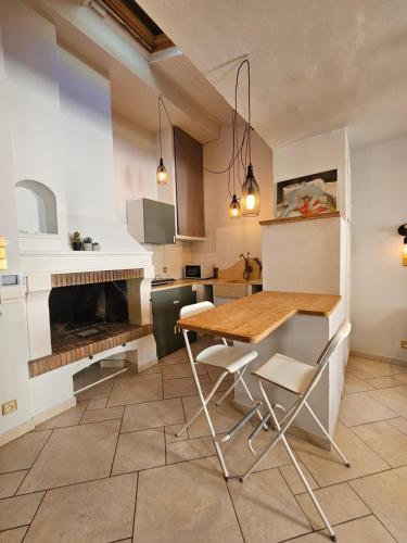 une cuisine avec une table en bois et une cheminée dans l'établissement Charmant studio à Toulon Centre, à Toulon