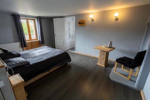 CHAMBRE D'HOTE في Granges-sur-Vologne: غرفة نوم بسرير وطاولة وكرسي