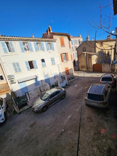 2 voitures garées dans un parking à côté d'un bâtiment dans l'établissement Charmant studio à Toulon Centre, à Toulon