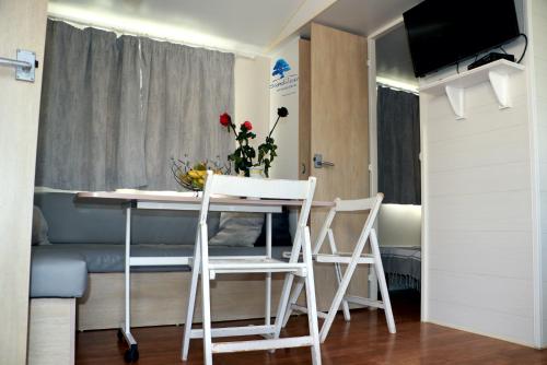 a small room with a table and chairs and a bed at Mobilhome Fun and Sun - 4-6 personnes-2 Chambres in Sigean