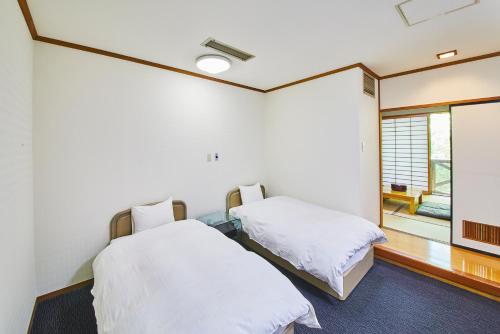 two beds in a room with a window at Shiki Resort Belufore Nasu in Nasu
