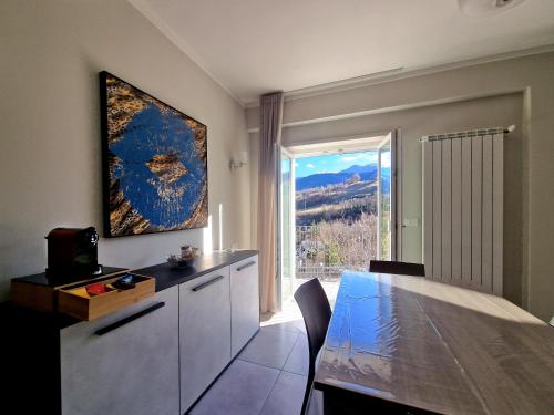 eine Küche mit einem Esstisch und einem großen Fenster in der Unterkunft Il Filo Rosso in LʼAquila