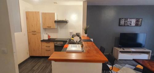 une petite cuisine avec un comptoir et une télévision dans l'établissement The Family - Bel Appartement 4/6 places, à Rouen