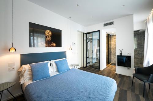 a bedroom with a blue bed and a television at HOTIDAY Room Collection - Olbia Wallure in Olbia