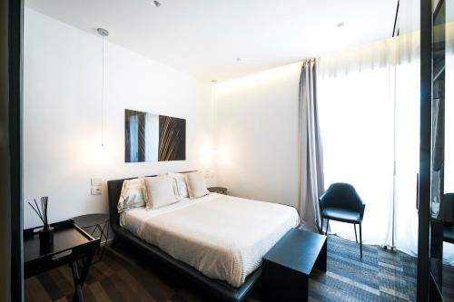 a hotel room with a bed and a chair at HOTIDAY Room Collection - Olbia Wallure in Olbia