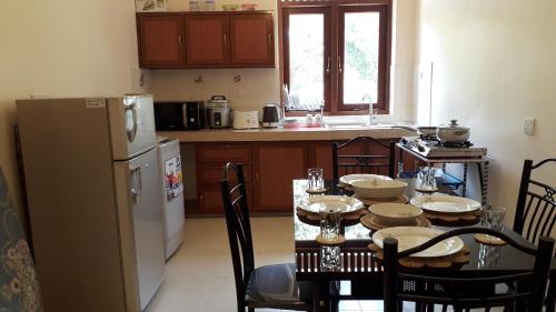 a kitchen with a table with chairs and a refrigerator at Binara House - Nugegoda, Colombo in Nugegoda