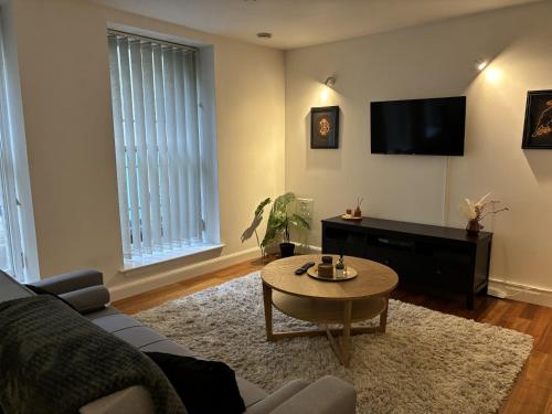 uma sala de estar com um sofá e uma mesa de centro em Apartment in the heart of Cardiff City Centre em Cardiff