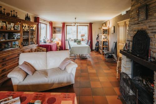 a living room with a white couch and a fireplace at Le refuge de Kila in Waimes