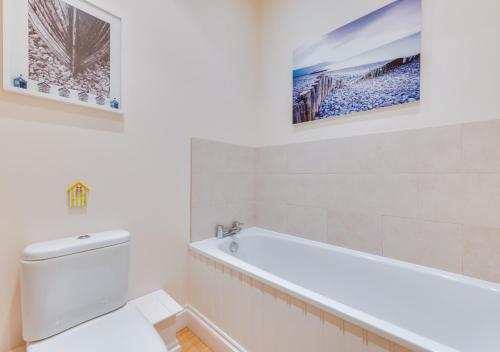 Meadow House في Blythburgh: حمام أبيض مع حوض ومرحاض