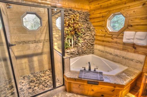 een badkamer met een bad en een wastafel bij Luxury Cabin Sleeps 8 with creekside fire pit near Helen GA in Cleveland