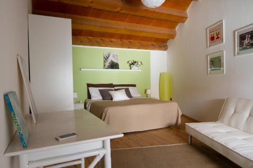ein Schlafzimmer mit einem Bett, einem Sofa und einem Tisch in der Unterkunft Dentro Le Mura in Catania