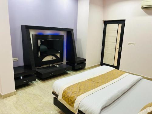 a bedroom with a bed and a flat screen tv at pool loft in Jaipur