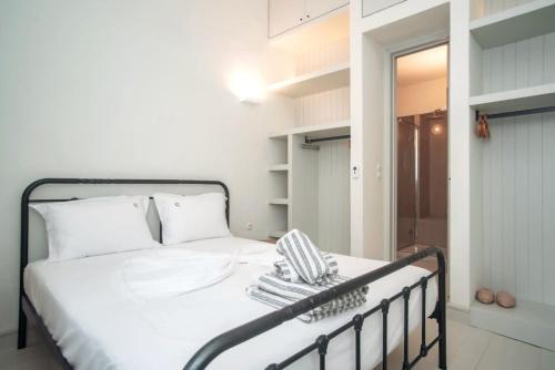a bedroom with a white bed with a black rail at Samos Serenity - Classic Retreat near the beach in Koumeika