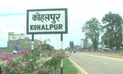 ein Schild am Straßenrand mit Blumen in der Unterkunft Khadka Niwas in Nepalganj