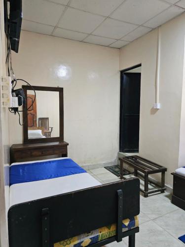 KilinochchiにあるHotel SELLA & Restのベッド、鏡、テーブルが備わる客室です。