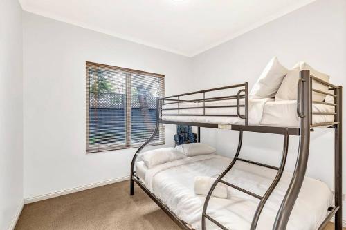 a room with two bunk beds and a window at Bayside Bungalow in Glenelg