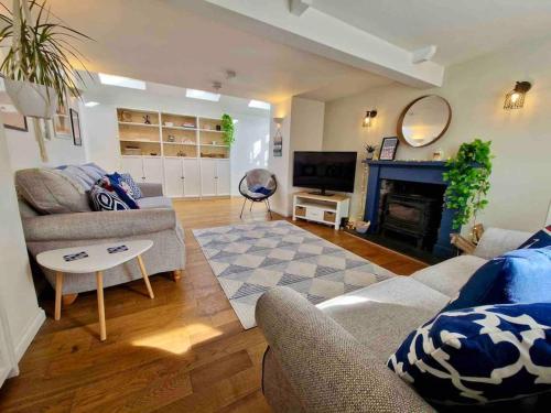 a living room with two couches and a fireplace at Cullen Seaside Cottage in Cullen