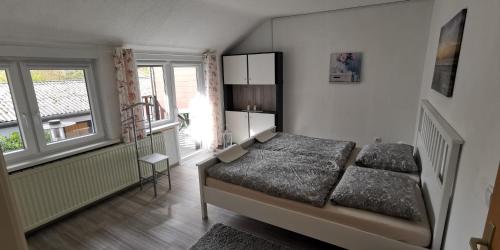 - une chambre avec un lit et 2 fenêtres dans l'établissement Ankes Ferienwohnung, à Bad Bederkesa