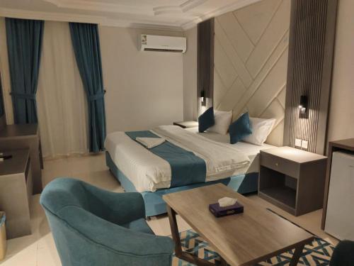 a hotel room with a bed and a table and chairs at شقق اطلالة أبحر للشقق المخدومة in Jeddah