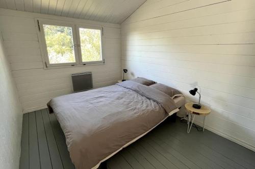 une petite chambre avec un lit et une fenêtre dans l'établissement Chalet au Domaine de l'Aven, à Villeneuve-Minervois