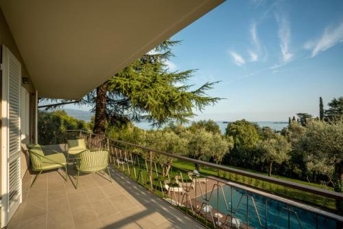 a house with a balcony with a swimming pool at Villa dei Lauri - villa vista lago con piscina in Salò