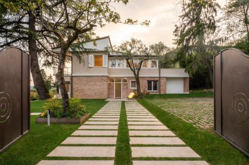 a house with a stone pathway leading to a house at Villa dei Lauri - villa vista lago con piscina in Salò