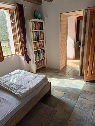 1 dormitorio con 1 cama y estantería con libros en Chambre triple, en Thorigné-sur-Dué