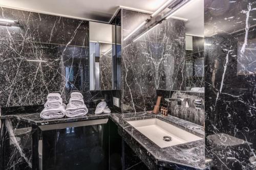a black marble bathroom with a sink and a mirror at Domus Mondrian Luxury House in Rome
