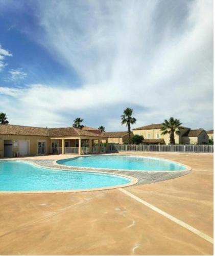 une grande piscine devant un immeuble dans l'établissement Maison le long du canal du Midi, à Béziers