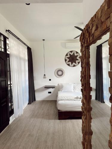 - une chambre avec un lit et une horloge murale dans l'établissement The Confidential Mandalika, à Kuta Lombok