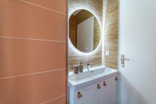y baño con lavabo y espejo. en Havre de Paix pastel en Studio !, en Villiers-sur-Marne
