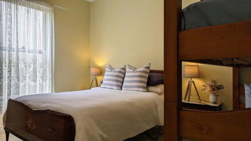 Dormitorio con litera y almohadas azules y blancas en Learmonth Guesthouse - Queenscliff, en Queenscliff