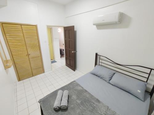 ein Schlafzimmer mit einem Bett mit zwei Hausschuhen darauf in der Unterkunft Luxpro Beachfront Homes Port Dickson in Port Dickson
