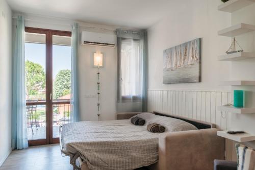 a bedroom with a bed and a large window at Moretto 10 - con piscina e WiFi in Sirmione