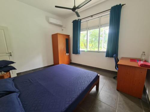 - une chambre avec un lit, un bureau et une fenêtre dans l'établissement Mattie's Hideout, à Kundasale
