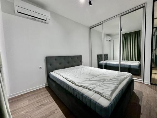 ein Schlafzimmer mit einem Bett und einem Spiegel in der Unterkunft CozyBoutique @subway in North in Pipera