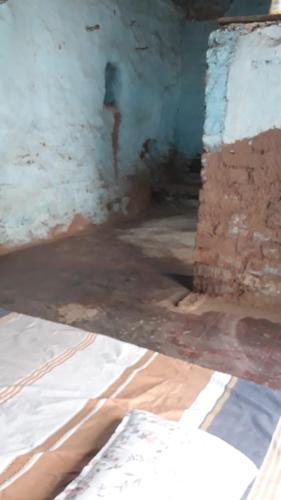an unfinished room with a brick wall and a floor at Mud House in Miraj