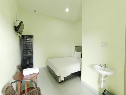 una piccola camera con letto e lavandino di Pudan Residence Balige By Helocus a Balige