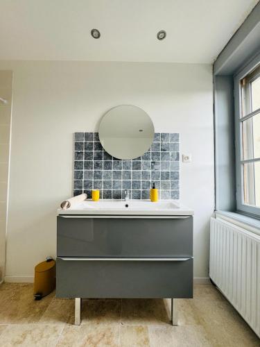 une salle de bain avec un lavabo et un miroir dans l'établissement Petite Demeure, à Paray-le-Monial