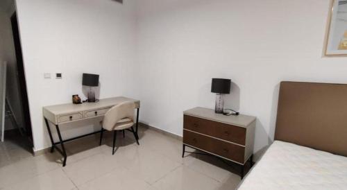a bedroom with a desk and a chair and a dresser at Holiday Room in Dubai