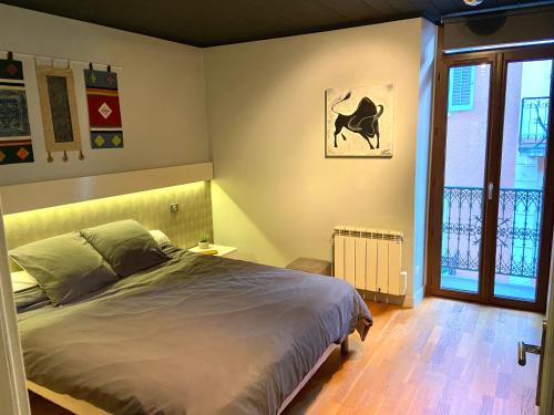 een slaapkamer met een bed en een raam bij L'Olivier in Aix-les-Bains
